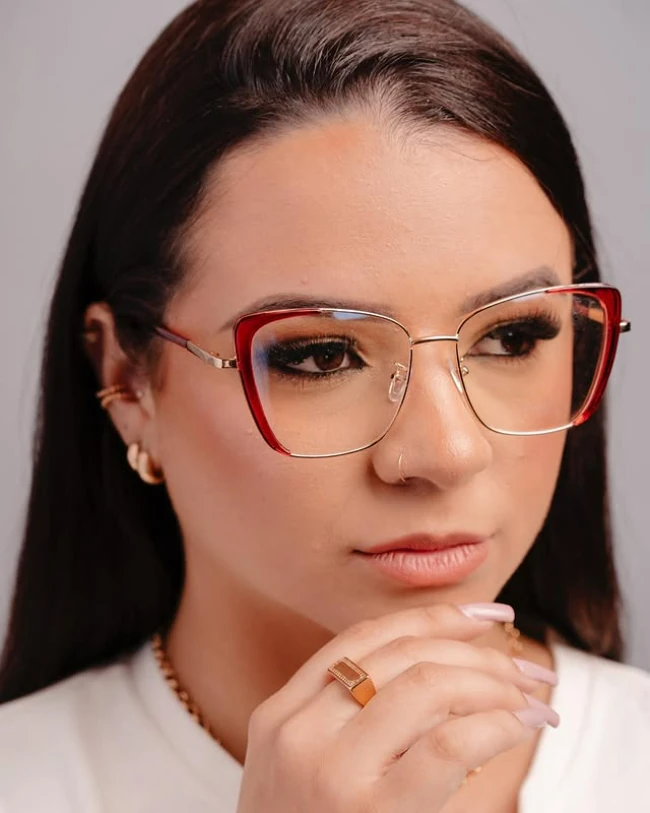 Modelo usando armação de grau vermelha e dourada